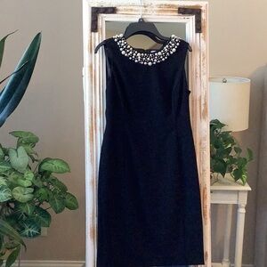 Calvin Klein black cocktail dress. Knee length with pearl like around neck.
